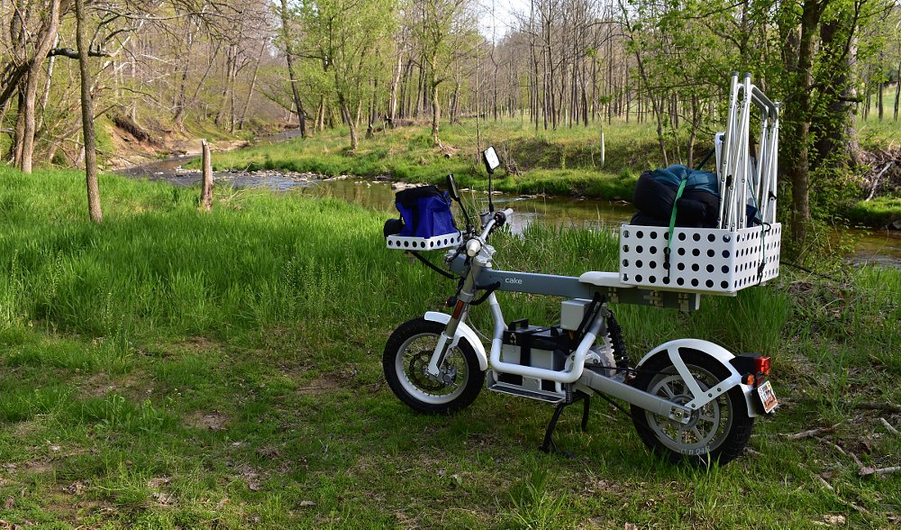 Gâteau Osa+ près d'un ruisseau, avec du matériel de camping.