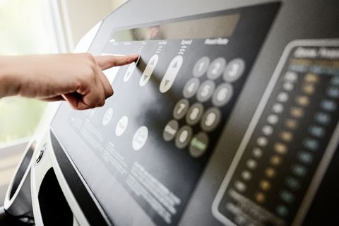 Femme méconnaissable ajustant les commandes d'un tapis roulant pour courir. Femme méconnaissable ajustant les commandes d'un tapis de course pour courir.