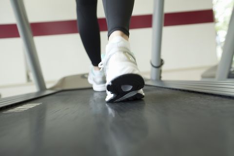 Coupe basse d'une femme faisant de l'exercice sur un tapis roulant. Coupe basse d'une femme faisant de l'exercice sur un tapis de course