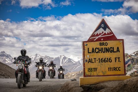 un groupe de personnes à moto près d'un panneau de signalisation