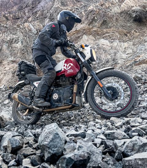 une personne conduisant une moto sur des rochers