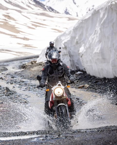 des gens qui font de la moto sur des chemins de terre pleins d'eau